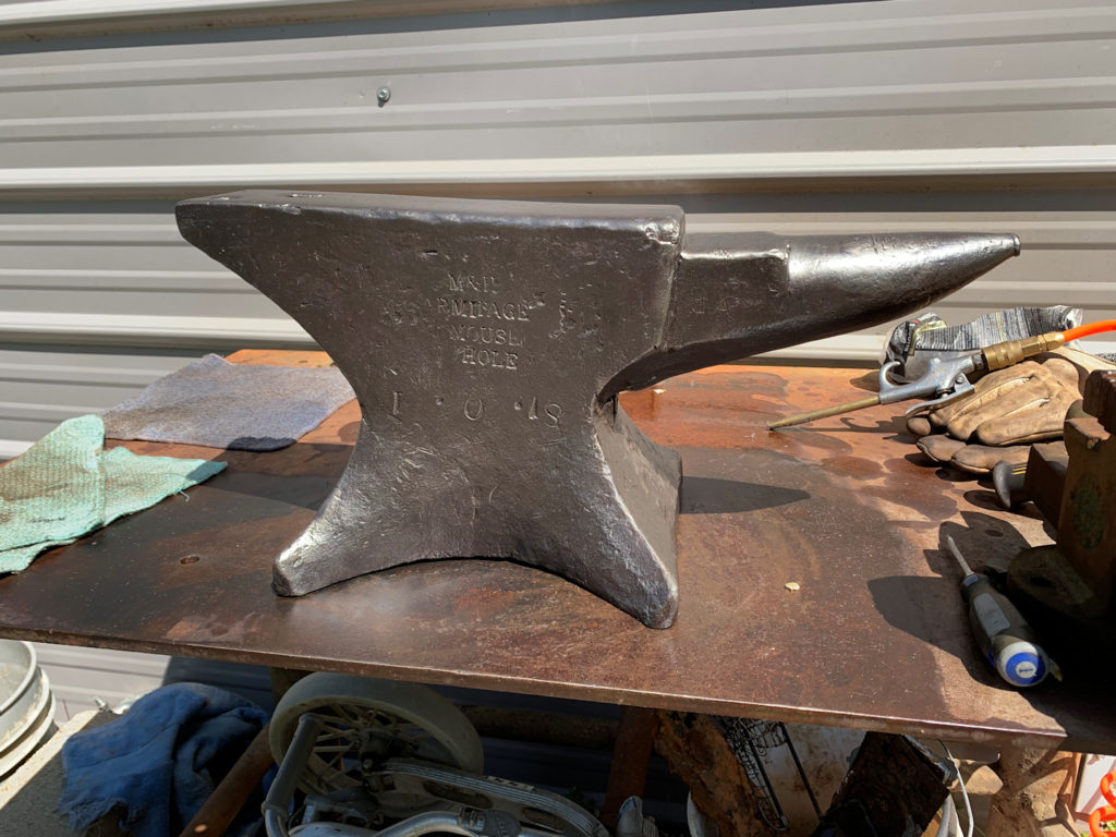 Cleaning up an old anvil on a workbench